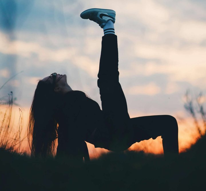 A sunrise with a person stretching outdoors